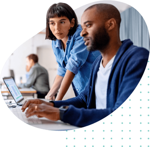 Photo of two people in an office setting looking at a computer screen