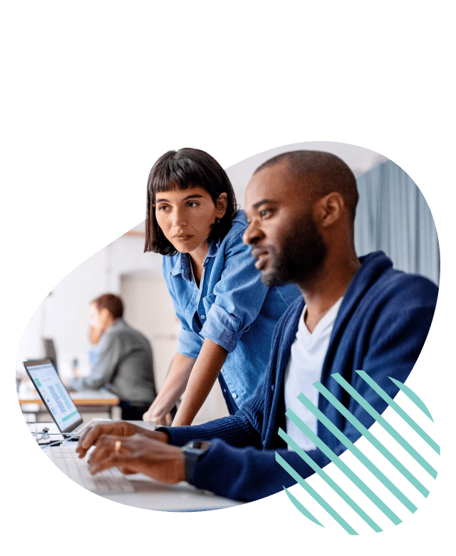 Stylized stock image of two coworkers working together at a desk looking at a screen