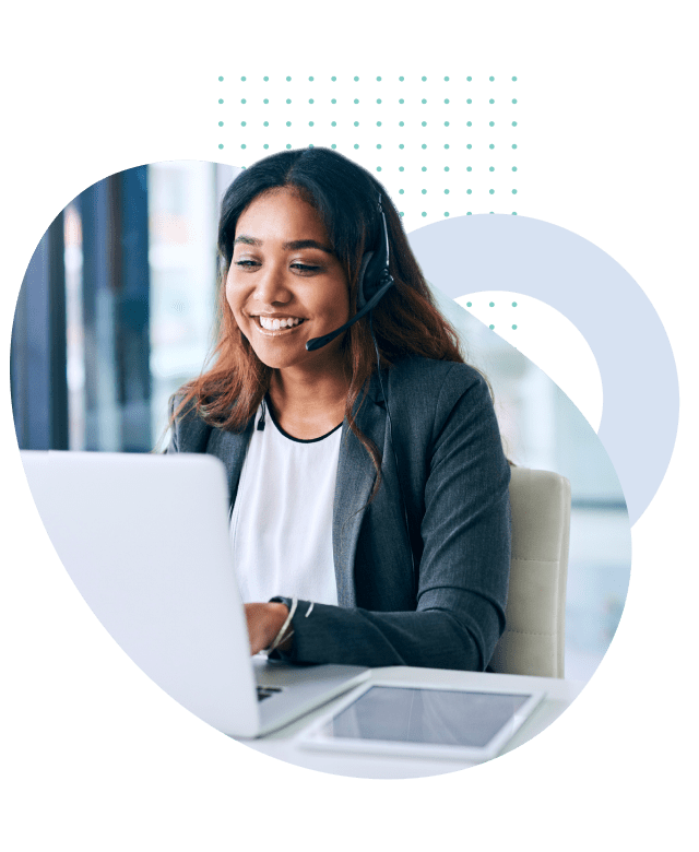 Photo of a woman wearing a headset and smiling while using a laptop