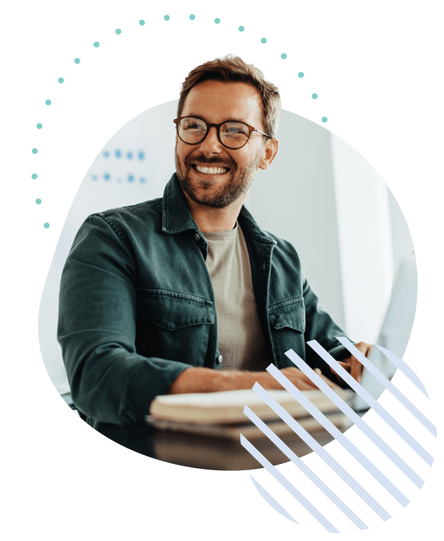 Man sitting in front of a laptop and smiling