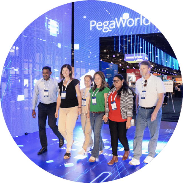 Photo of group of conference attendees standing in a mirror room with PegaWorld sign above